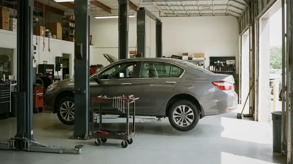 A sedan raised on a lift in an independent repair shop.